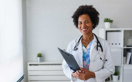 Black doctor smiling, standing in her office