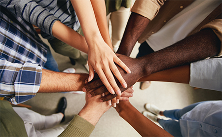 Hands-in team building cheer, viewed from above