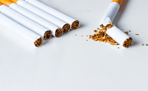 Group of 5 combustible cigarettes with a single broken cigarette out in front