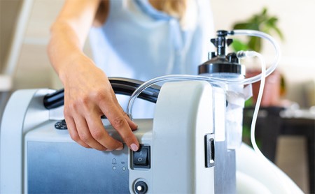 Mid-section shot of a woman switching on a medical machine.